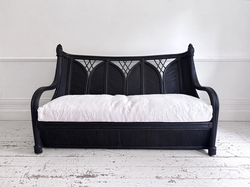 A 1950's French Black Rattan Sculptural Sofa with Piqué Upholstery
