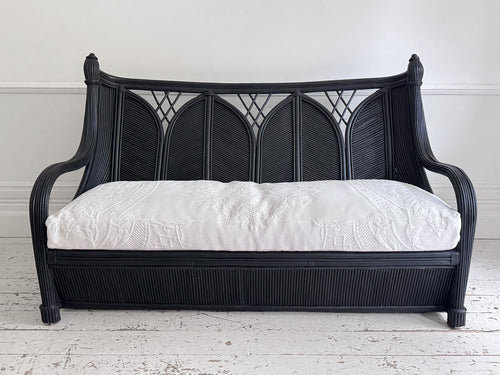A 1950's French Black Rattan Sculptural Sofa with Piqué Upholstery