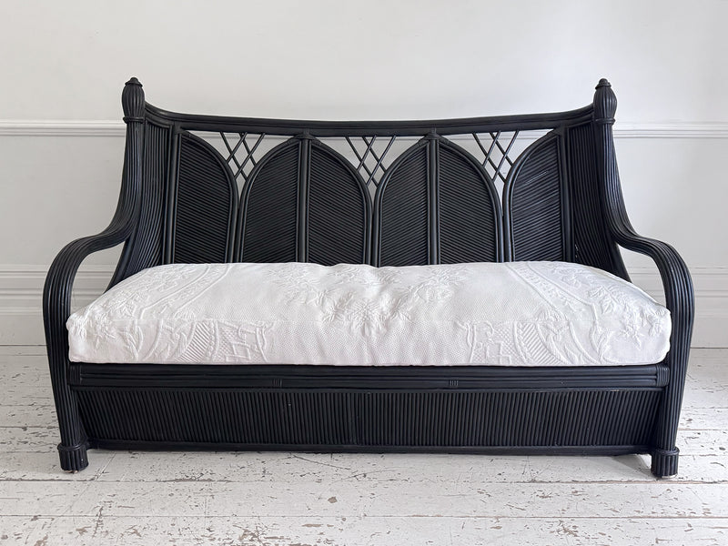 A 1950's French Black Rattan Sculptural Sofa with Piqué Upholstery
