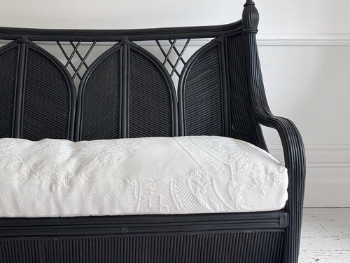 A 1950's French Black Rattan Sculptural Sofa with Piqué Upholstery
