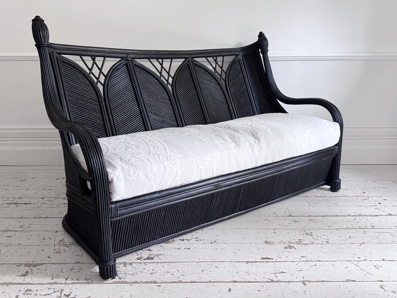A 1950's French Black Rattan Sculptural Sofa with Piqué Upholstery