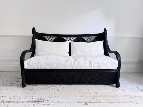 A 1950's French Black Rattan Sculptural Sofa with Piqué Upholstery