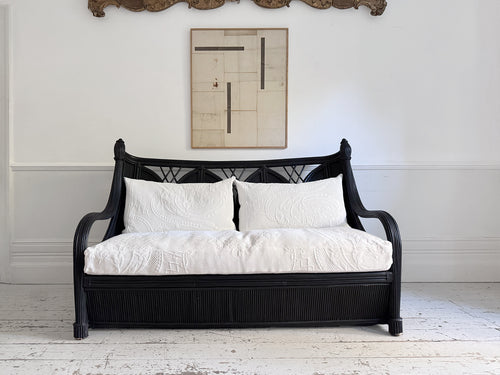 A 1950's French Black Rattan Sculptural Sofa with Piqué Upholstery