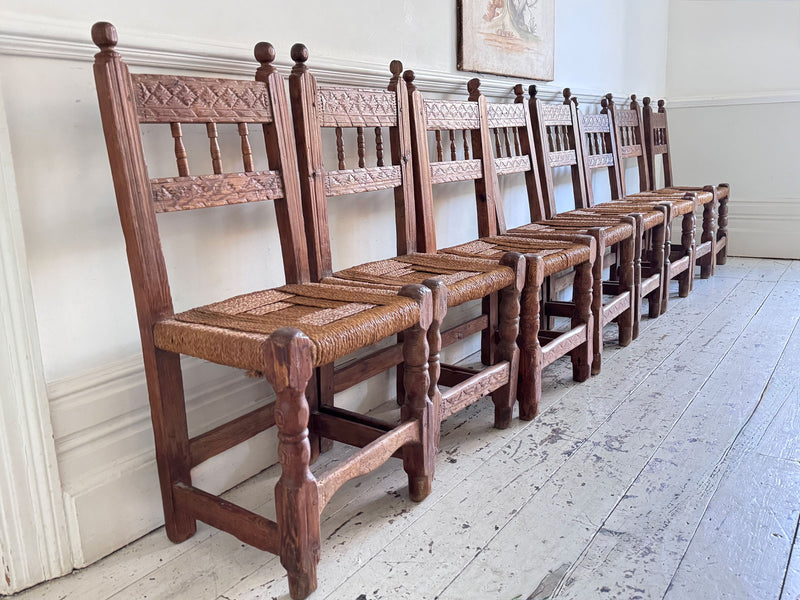 A Set of 8 Antique Spanish Folk Art Dining Chairs with Woven Seats