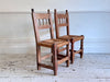 A Set of 8 Antique Spanish Folk Art Dining Chairs with Woven Seats