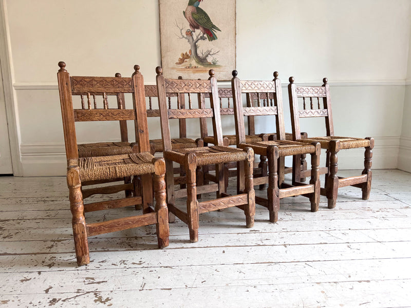 A Set of 8 Antique Spanish Folk Art Dining Chairs with Woven Seats