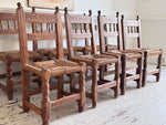 A Set of 8 Antique Spanish Folk Art Dining Chairs with Woven Seats