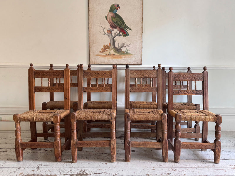 A Set of 8 Antique Spanish Folk Art Dining Chairs with Woven Seats