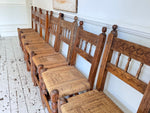 A Set of 8 Antique Spanish Folk Art Dining Chairs with Woven Seats