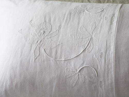 Antique linen bolster with delicate hand embroidered flowers by Charlotte Casadéjus