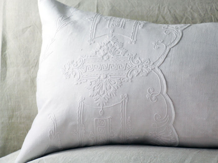 An antique linen bolster with scalopped Cornely embroidery by Charlotte Casadéjus