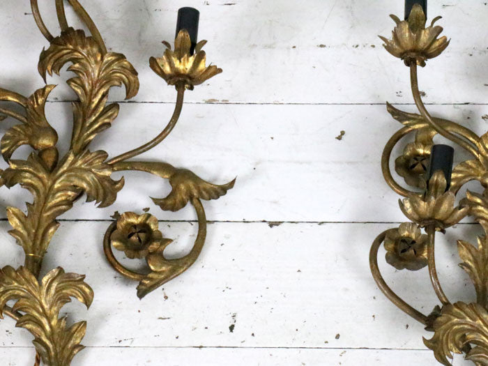 A large pair of gold metal relief wall lights