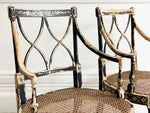 A Pair of Black Hepplewhite Caned Armchairs