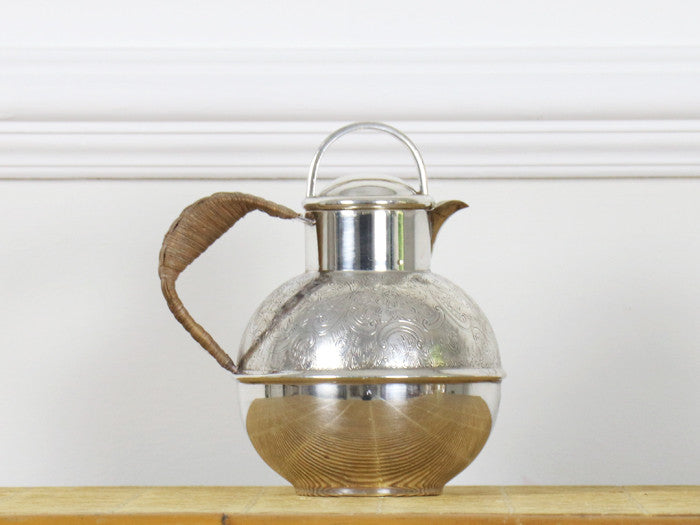 A 1950's etched silver plated tea pot with rattan handle